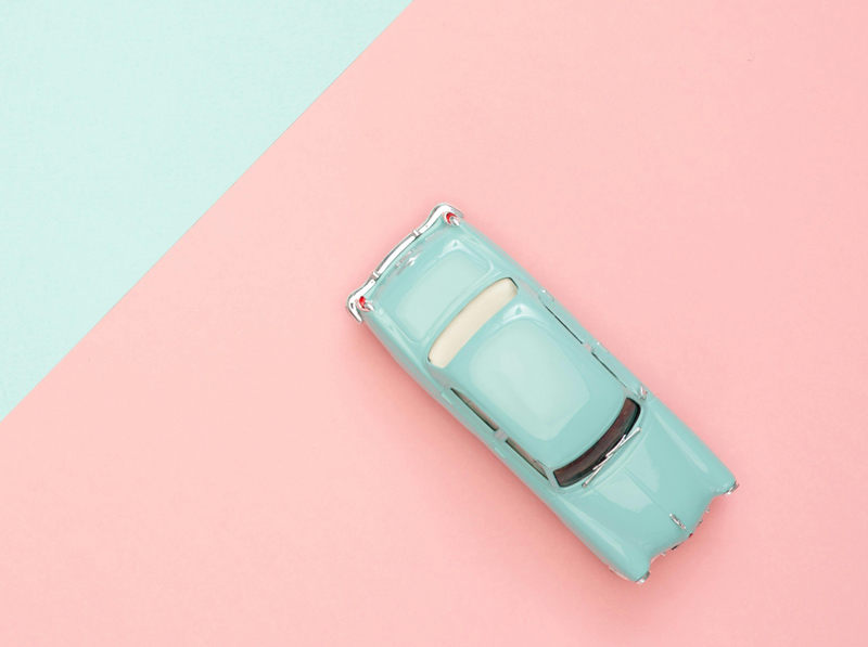 Stylish vintage car model on colorful background representing car insurance coverage